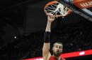 Jonas Valanciunas, pívot de los Raptors de Toronto, realiza una clavada entre Dennis Schroder (17) y Mike Muscala (31), de los Hawks de Atlanta, en el encuentro del viernes 20 de febrero de 2015 (AP Foto/John Amis)