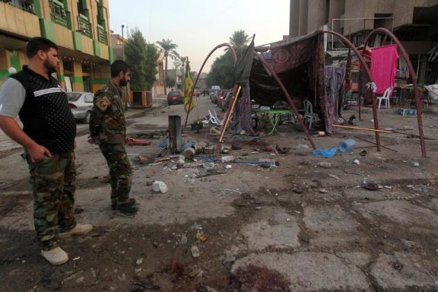 Las fuerzas de seguridad iraquíes inspeccionan el daño causado tras la detonación de un coche con explosivos cerca de una tienda donde se servían refrescos a peregrinos chiíes, en Bagdag el 2 de noviembre de 2014