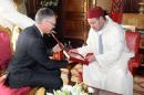 Le roi du Maroc Mohamed VI reçoit un cadeau des mains de Carlos Tavares, patron de PSA Peugeot Citroën, le 19 juin 2015 au palais royal de Rabat