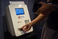 A customer feeds cash currency in to a Bitcoin ATM located in Flat 128, a boutique in New York's West Village, U.S. on August 22, 2014. REUTERS/Brendan McDermid/File Photo