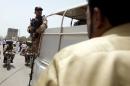 A paramilitary solder stands guard on a van outside   the hospital after an attack on a bus in Karachi