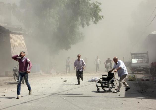 Syrian men react following a reported barrel bomb attack by Syrian government forces that hit an open market in the northern city of Aleppo, on June 2, 2015