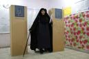 A woman casts her vote at a polling station during a   parliamentary election in Baghdad