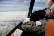 Flight Lieutenant Jayson Nichols looks out the cockpit of a Royal Australian Air Force AP-3C Orion aircraft over clouds while searching for missing Malaysian Airlines flight MH370 over the southern Indian Ocean March 27, 2014. REUTERS/Michael Martina
