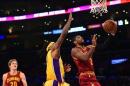 El base estadounidense Kyrie Irving, de los Cleveland Cavaliers, anota ante Jordan Hill (C), pívot de los Lakers, el 15 de enero de 2014, en Los Angeles