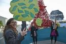 Representatives of NGOs hold cut out of trees and shout