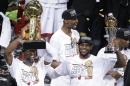 ARCHIVO - En imagen del 21 de junio de 2013 Dwyane Wade, izquierda, del Heat de Miami, sostiene el trofeo de campeonato de la NBA y LeBron James alza el trofeo al jugador más valioso de la final después del séptimo partido por el título frente a los Spurs de San Antonio, en Miami. Wade le informó al Heat el sábado 28 de junio de 2014 que se saldrá de sus últimos dos años y cerca de 42 millones de dólares de su contrato para convertirse en agente libre. (Foto AP/Wilfredo Lee, archivo)