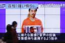 People walk past television screens displaying a news   program, about an Islamic State video showing Japanese captive Kenji Goto, in   Tokyo