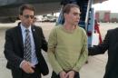 Luka Rocco Magnotta is taken by police from a Canadian military plane to a waiting van on Monday, June 18, 2012 in Mirabel, Que. The big-ticket military mission to fetch fugitive Luka Rocco Magnotta from Germany in 2012 was ordered by a senior Conservative cabinet minister who considered it a matter of "national interest," The Canadian Press has learned.THE CANADIAN PRESS/HO