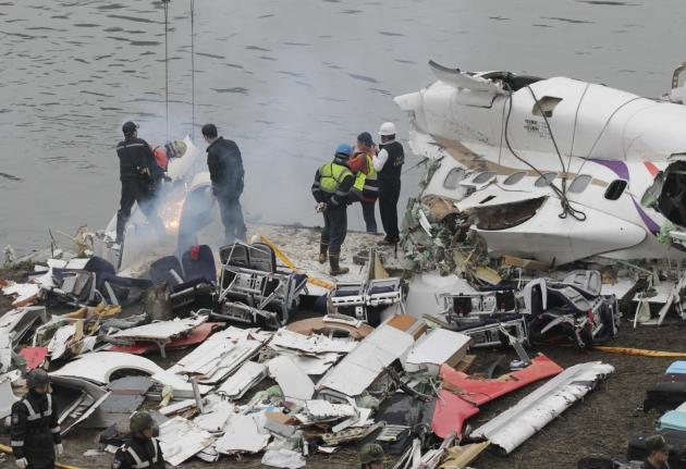 Equipos de rescatistas rompen piezas del fuselaje en el lugar donde se estrelló un avión comercial, en Taipei, Taiwan, el 5 de febrero de 2015. (Foto AP/Wally Santana)
