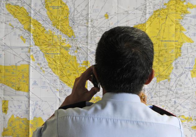 An airport official checks a map of Indonesia at the crisis center.