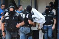 Forças especiais francesas levam mulher e criança não identificadas ao deixar edifício onde suspeito de atentado mora, em 26 de junho de 2015