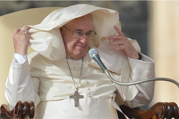 La esclavina del papa Francisco se levanta sobre su cabeza por el viento durante la audiencia semanal general en la plaza San Pedro del Vaticano, el 5 de noviembre de 2014