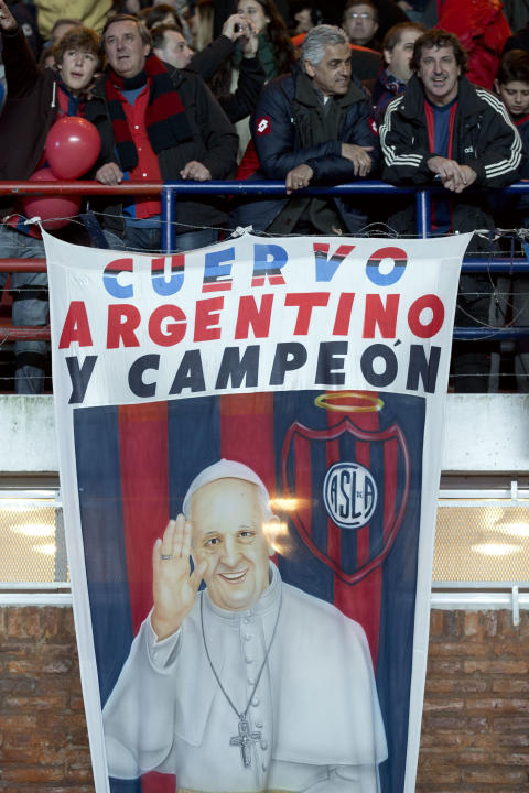 Los fans de la Argentina San Lorenzo de pie al lado de una bandera del Papa Francisco antes del inicio de un partido de fútbol final de la Copa Libertadores frente a Nacional de Paraguay en Buenos Aires, Argentina, el miércoles, Au