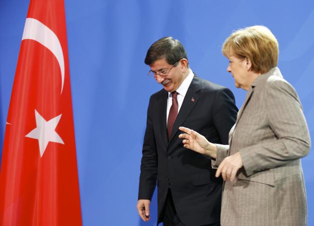 German Chancellor Angela Merkel speaks with Turkish Prime Minister Ahmet Davutoglu after they addressed the media upon their meeting at the Chancellery in Berlin, January 12, 2015. REUTERS/Hannibal Hanschke (GERMANY - Tags: POLITICS)