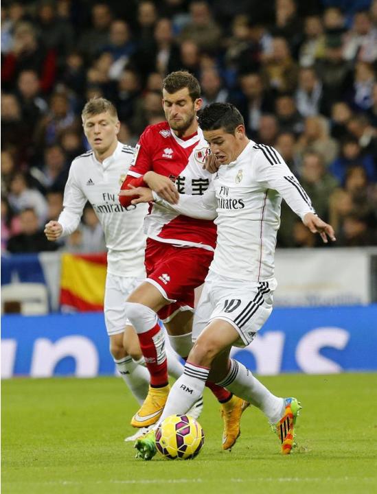 GRA313. MADRID, 08/11/2014.- El jugador colombiano del Real Madrid James Rodríguez (d) pelea un balón con el brasileño Baptistao (c), del Rayo Vallecano durante el partido de la undécima jornada de Li