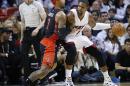 Chris Bosh, del Heat de Miami, trata de eludir a James Johnson, de los Raptors de Toronto, en el partido del domingo 2 de noviembre de 2014 (AP Foto/Joel Auerbach)