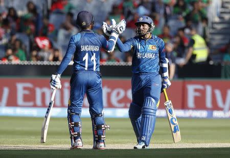 Sri Lankan batsman Tillakaratne Dilshan (R) reacts after scoring his 150 runs alongside team mate Kumar Sangakkara during their Cricket World Cup match against Bangladesh at the MCG in Melbourne, February 26, 2015. REUTERS/Brandon Malone