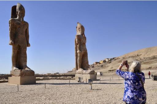 Turista fotografa as estátuas restauradas, no templo de Luxor