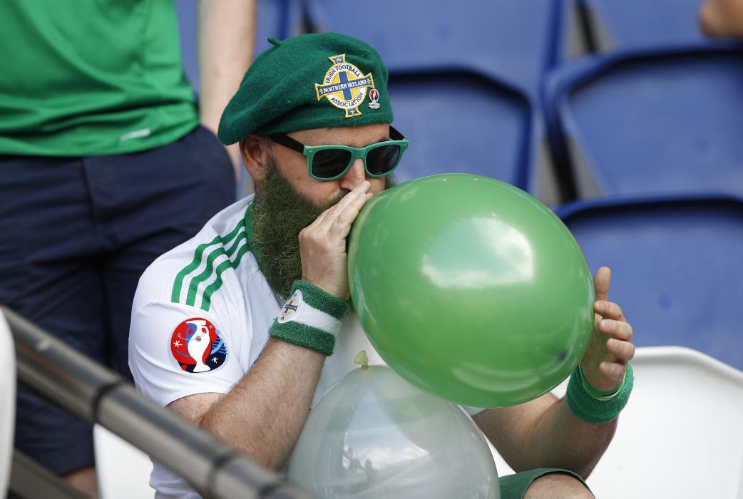 Northern Ireland fan blows up a balloon before the match