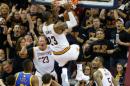 LeBron James (C), de los Cleveland Cavaliers, vuelca la pelota en la cesta de los Golden State Warriors, en el sexto juego final de la NBA, el 16 de junio de 2016 en Cleveland