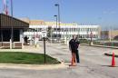 FILE - In this Sept. 26, 2014 file photo, a security guard stands in front of the air-traffic control center in Aurora, Ill., after all flights in and out of Chicago's two airports were halted following a fire at the facility. The Federal Aviation Administration is revamping its systems following the September sabotage and fire at a suburban Chicago facility that disrupted travel nationwide. FAA Administrator Michael Huerta said Monday, Nov. 24, 2014, the agency is working to reduce its response time to a major facility outage from days to hours. It took more than two weeks to fully repair the suburban Chicago center. (AP Photo/Daily Herald, Scott Sanders, File) MANDATORY CREDIT; MAGS OUT