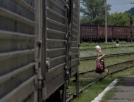 A woman looks at a refrigerated train loaded with the bodies of victims, in Torez, eastern Ukraine, 15 kilometers (9 miles) from the crash site of Malaysia Airlines Flight 17, Sunday, July 20, 2014. Armed rebels forced emergency workers to hand over all 196 bodies recovered from the Malaysia Airlines crash site and had them loaded Sunday onto refrigerated train cars bound for a rebel-held city, Ukrainian officials and monitors said. (AP Photo/Vadim Ghirda)