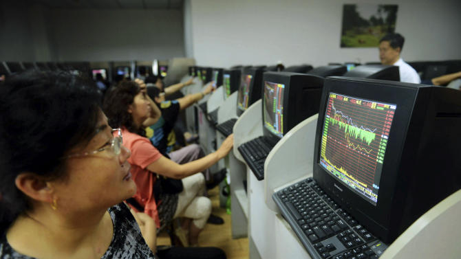 In this photo taken Monday, July 6, 2015, a stock investor monitors the Shanghai Composite Index at a brokerage house in Qingdao in east China's Shandong province. Chinese stocks fell Tuesday despite official efforts to shore up slumping prices while other Asian markets were mixed after Wall Street's decline. (Chinatopix Via AP) CHINA OUT