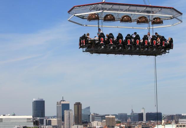 People have lunch at a table suspended from a crane at a height of 40 metres (131 ft) overlooking Brussels, Friday June 6, 2014. Warm temperatures are expected to continue through the weekend with a c