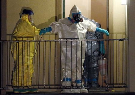 A worker in a hazardous material suit is sprayed down by a co-worker after coming out of an apartment unit where a man diagnosed with the Ebola virus was staying in Dallas, Texas, October 5, 2014. REUTERS/Jim Young