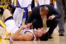 El alero Klay Thompson de los Warriors de Golden State recibe asistencia médica tras un golpe en la cabeza cuando enfrentaban a los Houston Rockets durante un partido de la final de la Conferencia Oeste de la NBA jugado el 27 de mayo de 2015 en Oakland, California