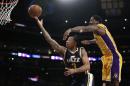 En la imagen, el jugador del Jazz de Utah Trey Burke, en el centro, lanza a canasta presionado por el jugador de los Lakers de Los Ángeles Ed Davis, en su partido de NBA del 19 de marzo de 2015 en Los Ángeles. (AP Foto/Jae C. Hong)