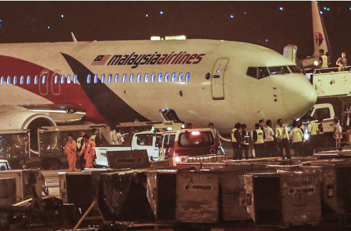 Ground crew check the Malaysia Airlines flight MH192 bound for Bangalore that turned back towards and parked at Kuala Lumpur International Airport in Sepang, Malaysia, Monday, April 21, 2014, after its right landing gear malfunctioned upon takeoff. The airline says Flight 192 carrying 166 people landed safely at the Kuala Lumpur International Airport early Monday, four hours after it departed. (AP Photo/Vincent Thian)