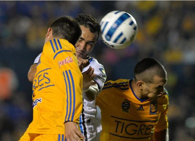 MEX33. MONTERREY (MÉXICO), 01/11/2014.- Jorge Torres (d) de Tigres disputa el balón con Mario Osuna (c) de Querétaro hoy, sábado 1 de noviembre de 2014, durante el partido correspondiente a la jornada