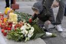 A child lights a candle outside a nightclub, where a   fire broke out on Friday, in Bucharest