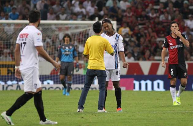 MEX56. GUADALAJARA (MÉXICO), 30/09/2014.- Un aficionado salta a la cancha para abordar al jugador Ronaldinho, de Querétaro, hoy, martes 30 de septiembre de 2014, durante un partido entre Atlas y Queré