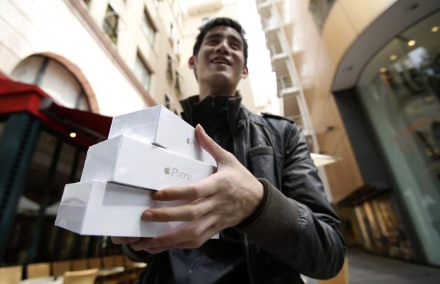 Canadian Jastin Leung holds some of his Apple iPhone 6 near the Apple Store at Tokyo's Omotesando shopping district