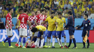 Referee Yuichi Nishimura from Japan gives Brazil's Neymar (10) a yellow card during the group A World Cup soccer match between Brazil and Croatia, the opening game of the tournament, in the Itaquerao Stadium in Sao Paulo, Brazil, Thursday, June 12, 2014. (AP Photo/Felipe Dana)