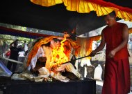 A Buddhist monk lights the funeral pyre of Nepalese climber Ang Kaji Sherpa killed in an avalanche on Mount Everest, in Katmandu, Nepal, Monday, April 21, 2014. Buddhist monks cremated the remains of Sherpa guides who were buried in the deadliest avalanche ever recorded on Mount Everest, a disaster that has prompted calls for a climbing boycott by Nepal's ethnic Sherpa community. The avalanche killed at least 13 Sherpas. Three other Sherpas remain missing and are presumed dead. (AP Photo/Niranjan Shrestha)