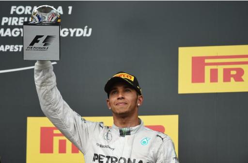 Mercedes' British driver Lewis Hamilton celebrates on the podium after the Hungarian Formula One Grand Prix at the Hungaroring circuit in Budapest on July 27, 2014