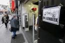 A placard reading Molenbeek with a "peace and   love sign" is seen in a shopping street in the suburb of Molenbeek