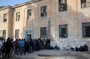 Refugees and migrants line up for food distribution   at a temporary refugee camp on the Greek island of Leros