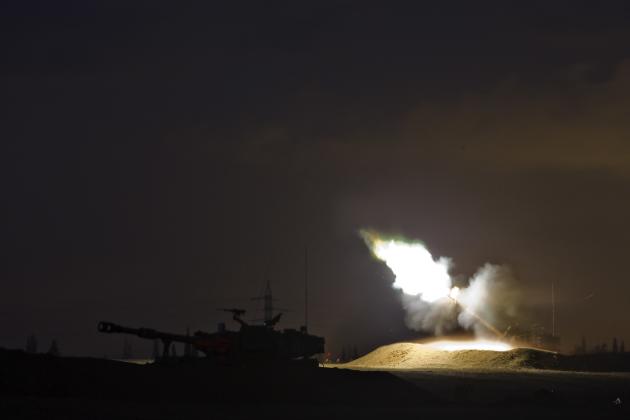 An Israeli mobile artillery unit fires towards Gaza from outside the Gaza Strip