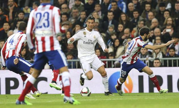 GRA325. MADRID, 15/01/2015.- El delantero portugués del Real Madrid Cristiano Ronaldo con el balón ante el defensa del Atlético de Madrid Juanfran Torres (d), durante el partido de vuelta de los octav