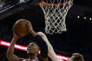 Damian Lillard, de los Trail Blazers de Portland, trata de encestar junto a Luke Babbitt, de los Pelicans de Nueva Orleáns, en el partido del sábado 20 de diciembre de 2014 (AP Foto/Butch Dill)