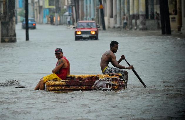 Cubanos improvisam jangada durante chuva forte, no dia 30 de abril de 2015, em Havana