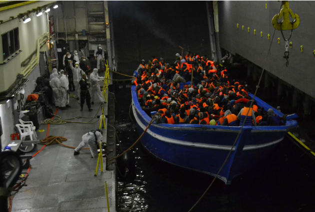 In this photo released by the Italian Navy on May 22, 2014, a fishing boat filled with migrants is towed into the Navy ship San Giorgio headed to Sicily. (AP Photo/Italian Navy, ho)