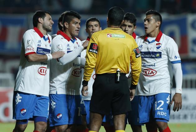 Coronel y compañeros de equipo de Nacional protesta del Paraguay sobre aa tiro penal a favor de la Argentina San Lorenzo durante la Copa Libertadores segunda etapa partido de fútbol final en Buenos Aires