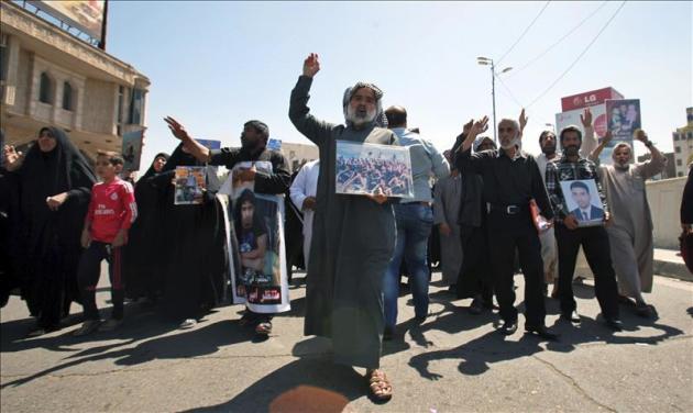 Varios iraquíes sostienen fotografías de sus familiares, que se cree fueron asesinados tras la toma de la base militar Speicher por el grupo yihadista Estado Islámico (EI), durante una manifestación en Al Tahrir, Bagdad. EFE/Archivo