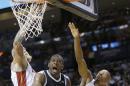 Joe Johnson, escolta de los Nets de Brooklyn, salta para encestar entre Chris Andersen (izquierda) y Ray Allen (34), del Heat de Miami, en el partido del martes 8 de abril de 2014 (AP Foto/Wilfredo Lee)